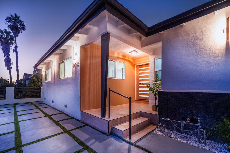 A BuildXpress home at twilight — warm entry light on a finished remodel